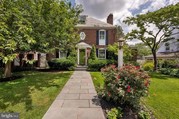 a front view of yellow house with garden