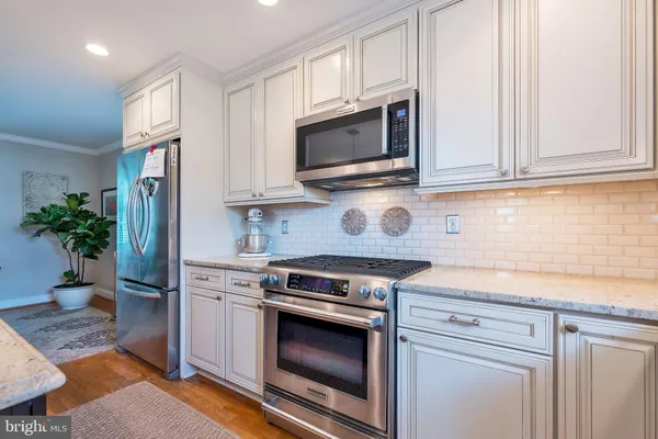 a kitchen with stainless steel appliances granite countertop a stove microwave and refrigerator