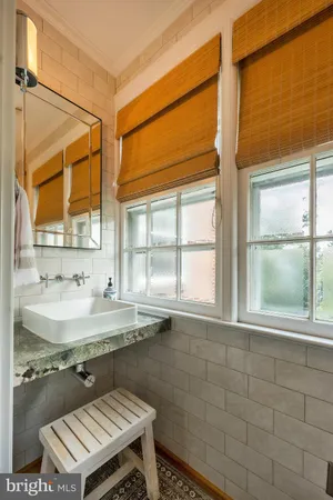 a bathroom with a granite countertop sink and a window