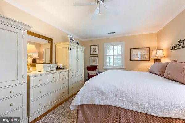 a bedroom with a large bed and dresser with mirror