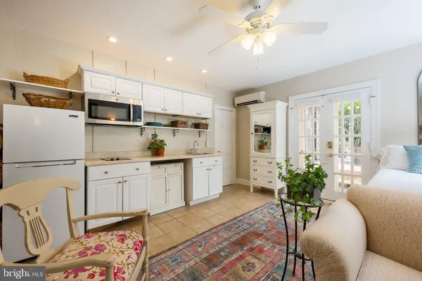 a kitchen with white cabinets and white appliances