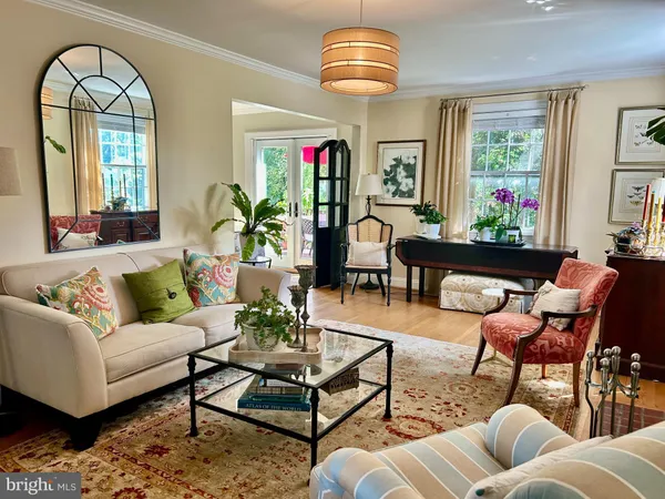 a living room with furniture chandelier and a large window
