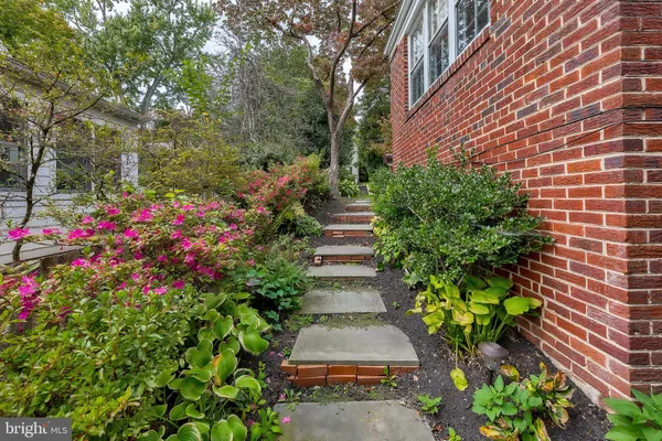 a view of a patio with table and chairs potted plants and large tree