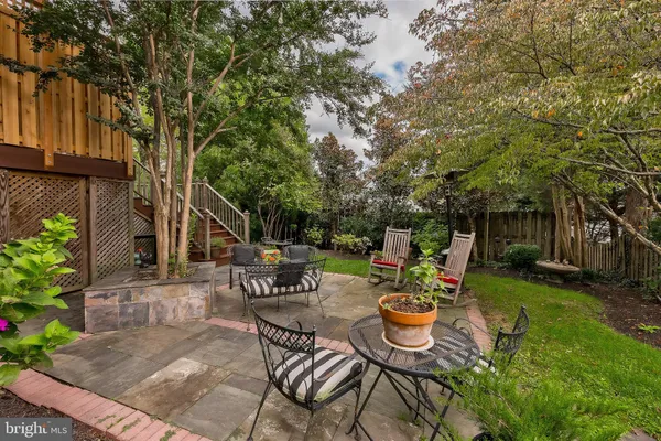 a view of a chair and table in backyard of the house