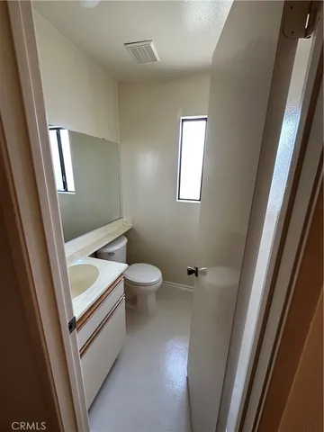 a bathroom with a toilet a sink and a mirror