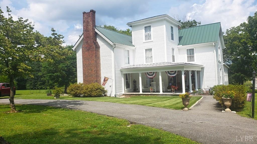 a front view of a house with a yard and trees