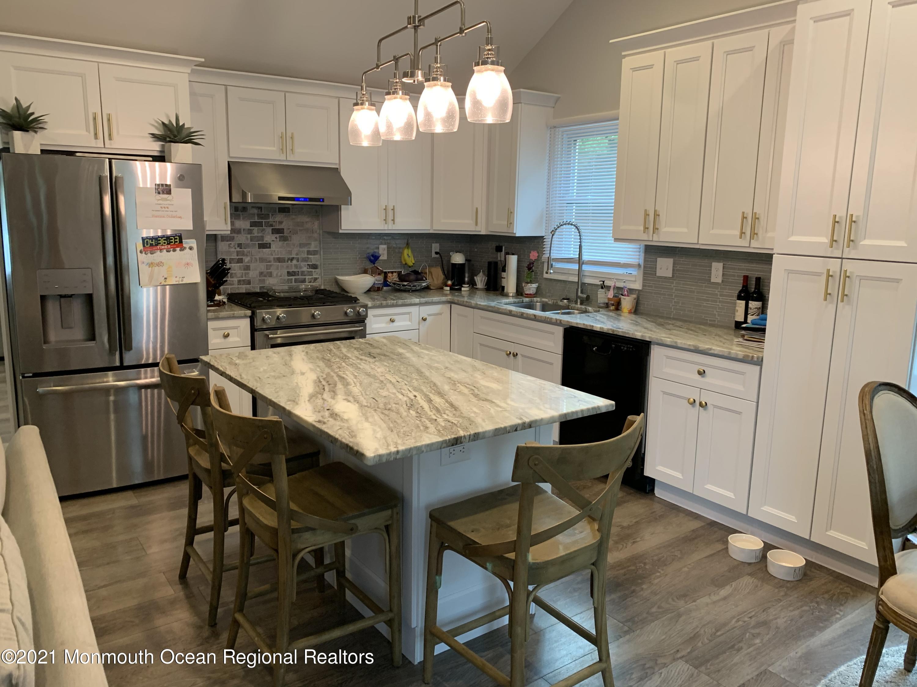 34 Forrest Avenue Rumson, NJ 07760 - Photo 7 of 22 a kitchen with stainless steel appliances kitchen island granite countertop a table chairs stove and refrigerator