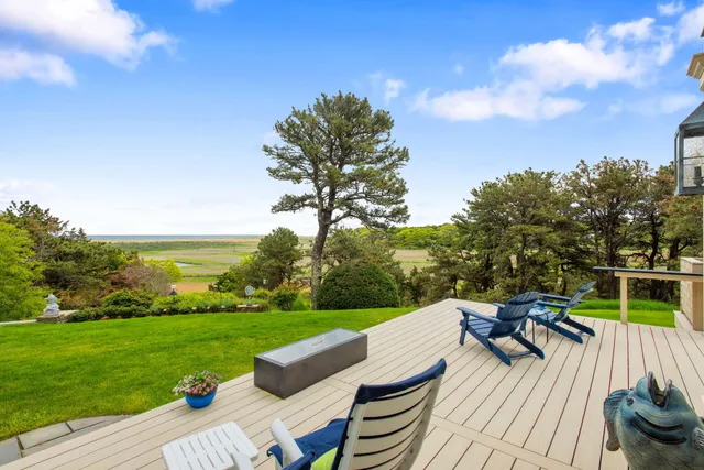 a kitchen with stainless steel appliances kitchen island a table chairs in it and white cabinets