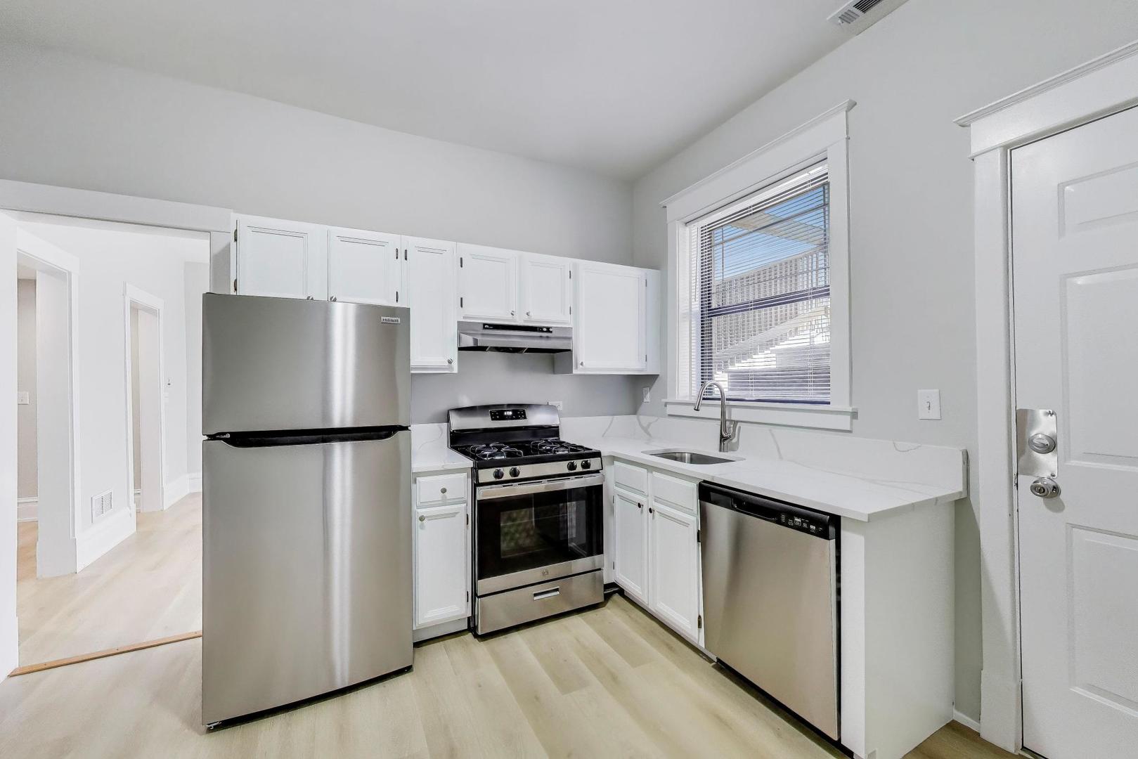 2114 West Byron Street, Unit 1 Chicago, IL 60618 - Photo 14 of 23 a kitchen with stainless steel appliances a refrigerator a stove a sink and a window