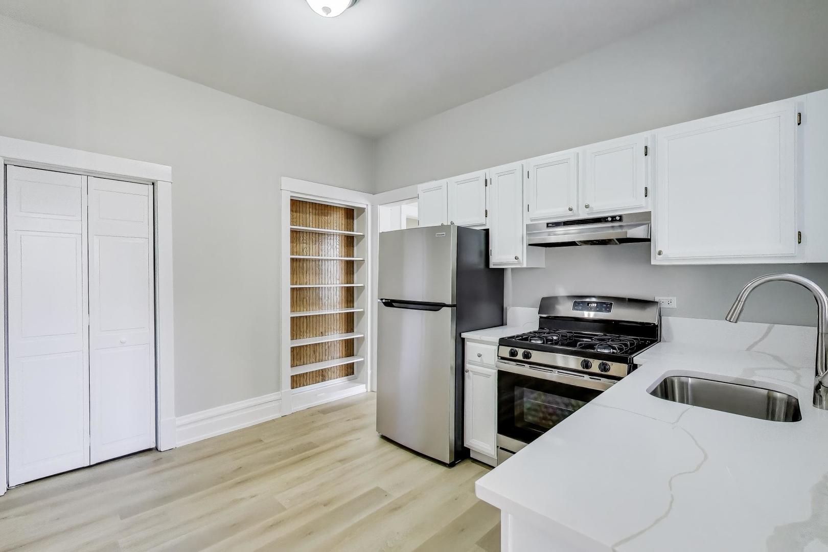 2114 West Byron Street, Unit 1 Chicago, IL 60618 - Photo 15 of 23 a kitchen with wooden cabinets and a stove top oven