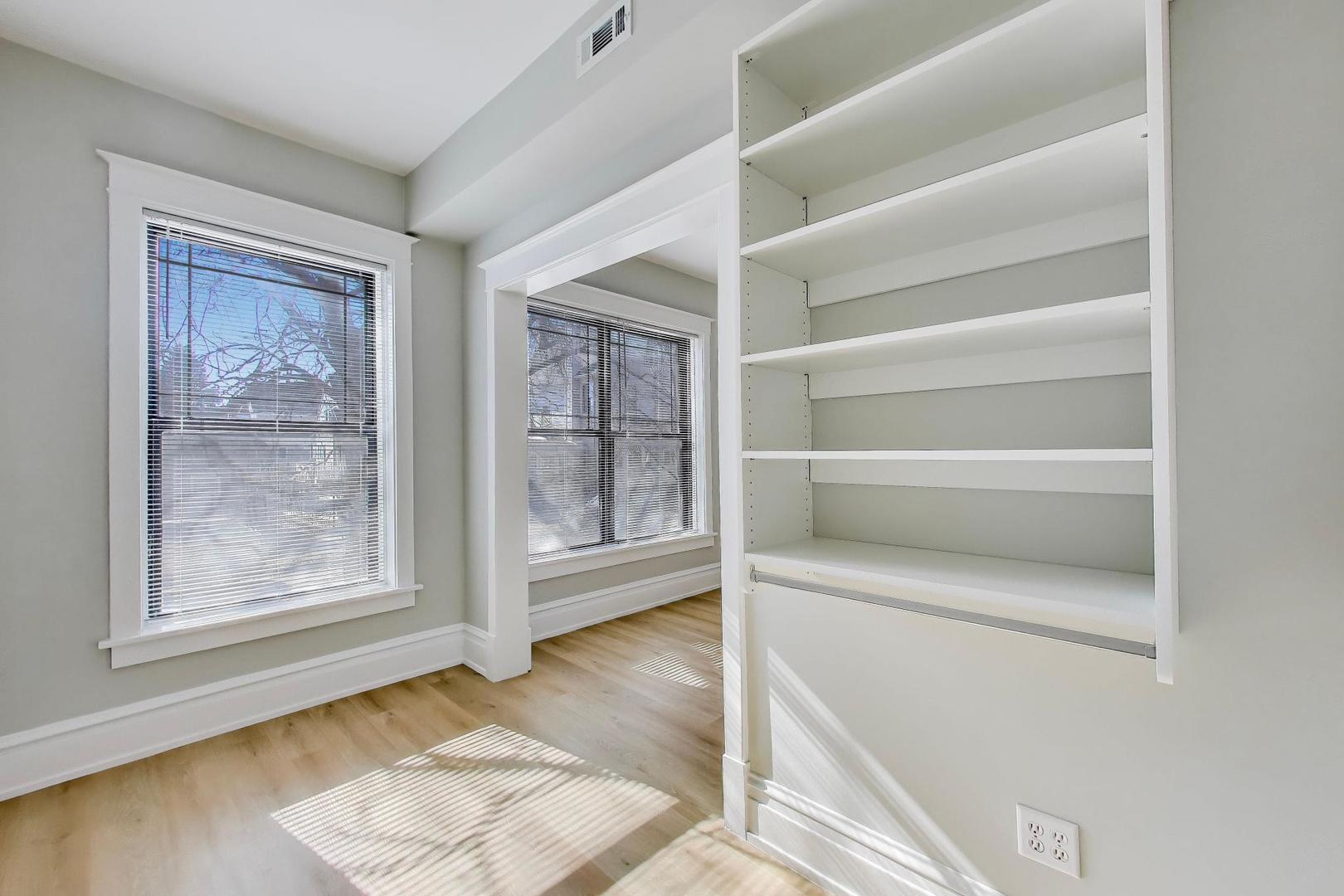 2114 West Byron Street, Unit 1 Chicago, IL 60618 - Photo 17 of 23 a view of an empty room with wooden floor and a window