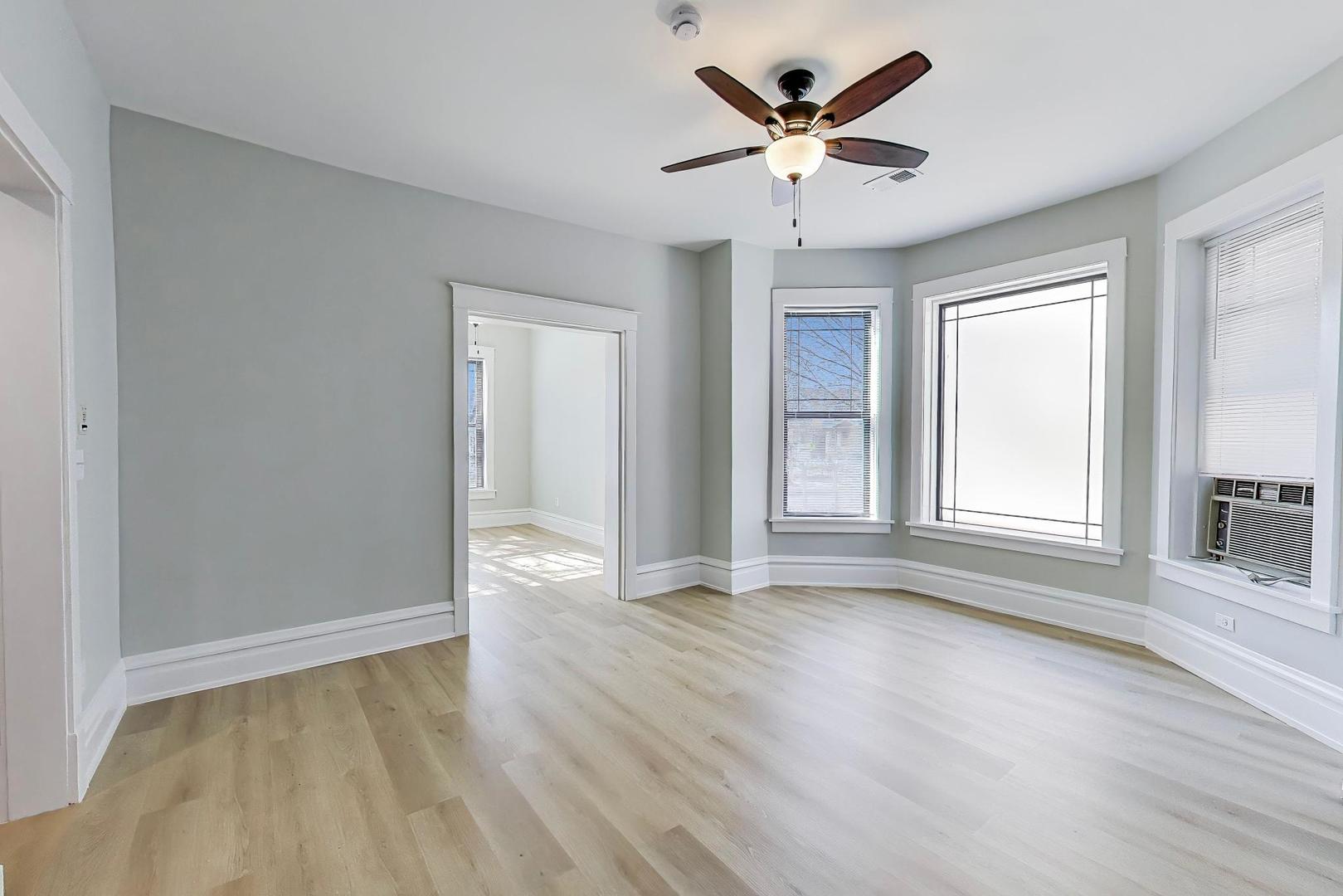 2114 West Byron Street, Unit 1 Chicago, IL 60618 - Photo 8 of 23 an empty room with wooden floor and windows