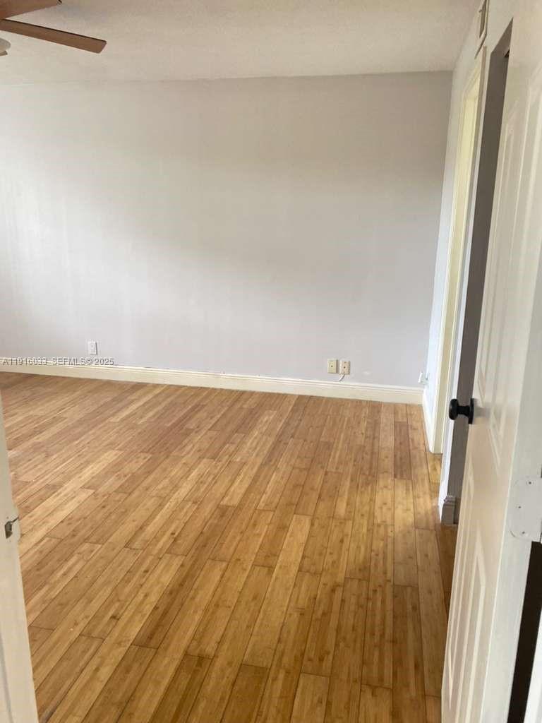 8901 Wiles Road, Unit 103 Coral Springs, FL 33067 - Photo 11 of 14 wooden floor in a white room