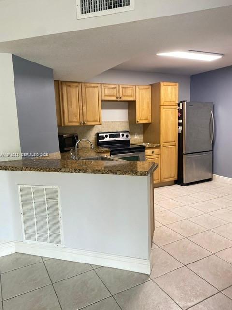 8901 Wiles Road, Unit 103 Coral Springs, FL 33067 - Photo 12 of 14 a kitchen with stainless steel appliances granite countertop a stove a sink and a refrigerator