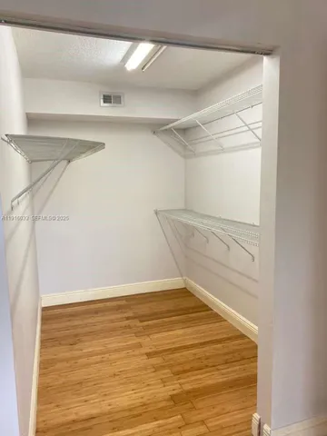 a view of walk in closet with empty racks