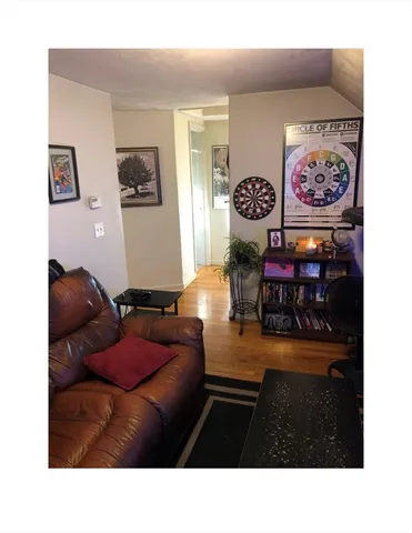 a living room with furniture and a wall painting