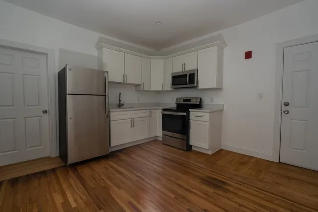 a kitchen with a refrigerator and a stove top oven