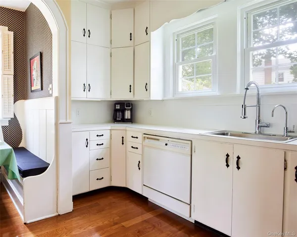 a view of a hallway with wooden floor and a living room