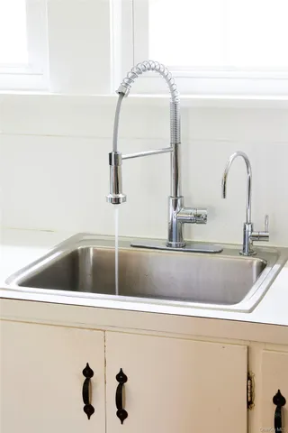 a bathroom with a sink and a stove a refrigerator