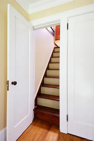 a view of a hallway with wooden floor and stairs