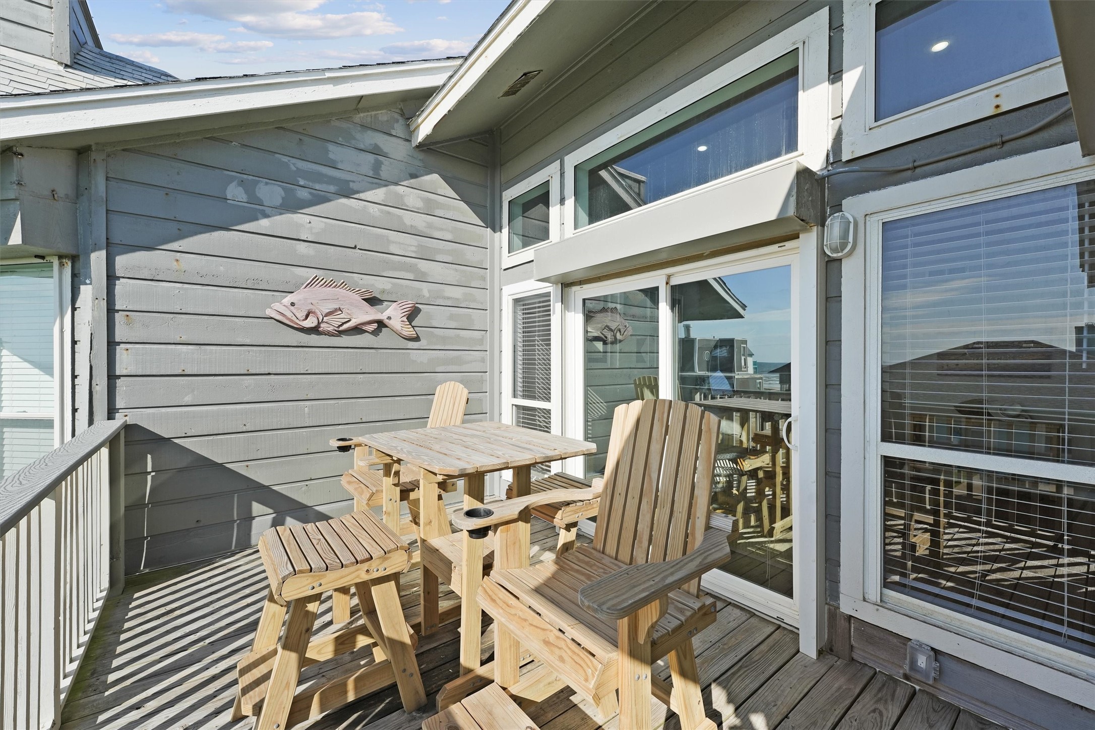 17607 Termini-San Luis Pass Road Galveston, TX 77554 - Photo 6 of 42 The balcony off the living room features charming wooden seating. This outdoor space is perfect for morning coffee while enjoying the coastal breeze.