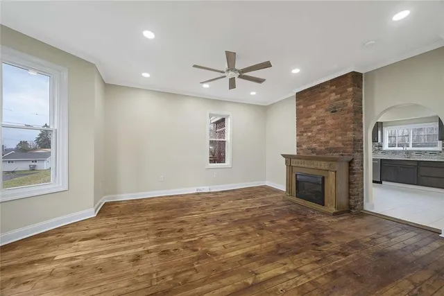 a view of an empty room with window and wooden floor