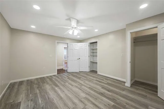 a view of empty room with wooden floor and window