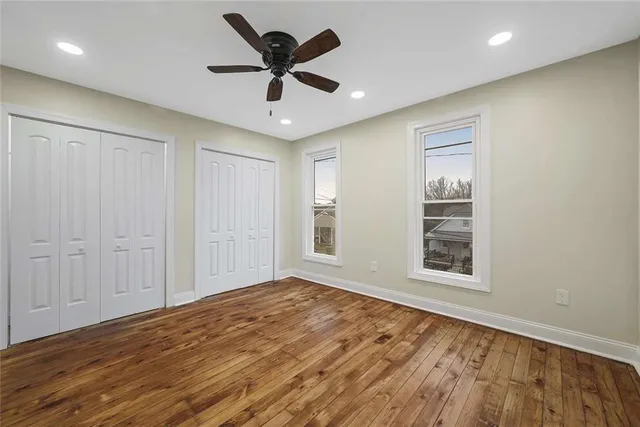 wooden floor in an empty room with a ceiling fan
