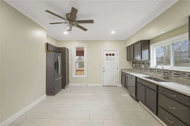 a large white kitchen with a sink and dishwasher a stove top oven with wooden floor