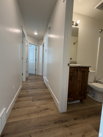 3831 South Powderwood Lane Mapleton, UT 84664 - Photo 12 of 17 Hallway featuring wood-finish flooring, recessed lighting, and white baseboards