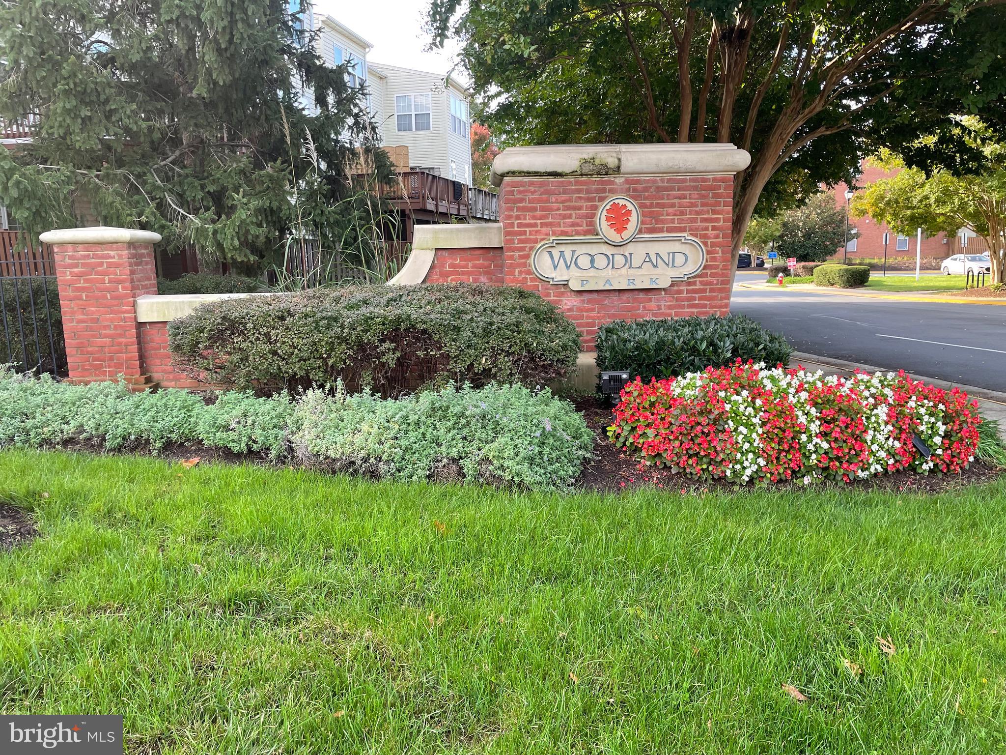 12968 Wood Cres Circle Herndon, VA 20171 - Photo 4 of 33 a sign that is sitting in the grass next to a road