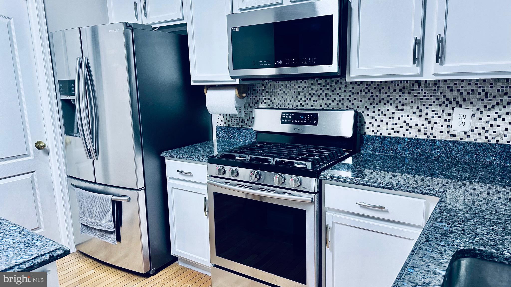 12968 Wood Cres Circle Herndon, VA 20171 - Photo 7 of 33 a kitchen with granite countertop a stove and a microwave