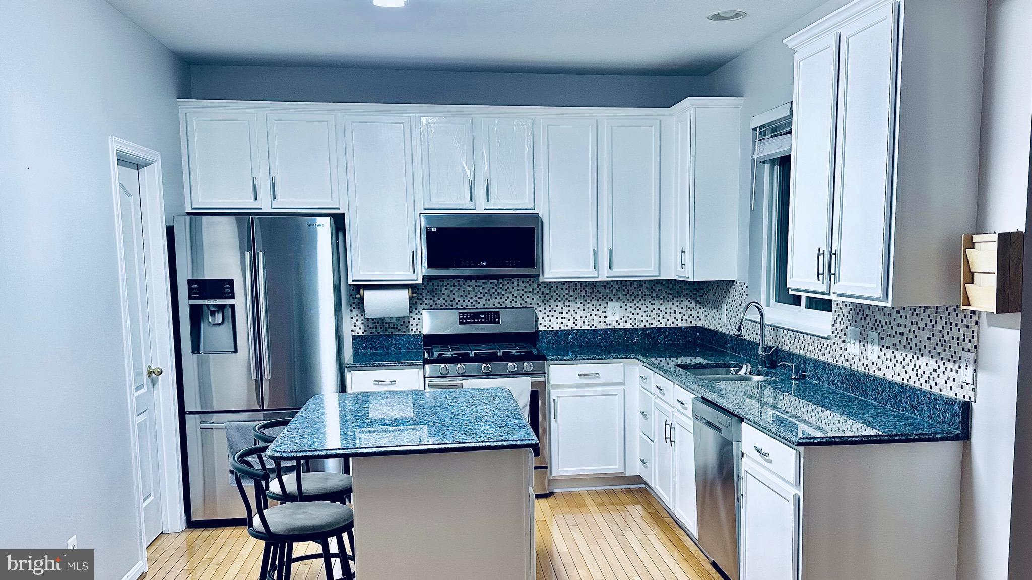 12968 Wood Cres Circle Herndon, VA 20171 - Photo 8 of 33 a kitchen with stainless steel appliances granite countertop a stove top oven a refrigerator a sink and white cabinets