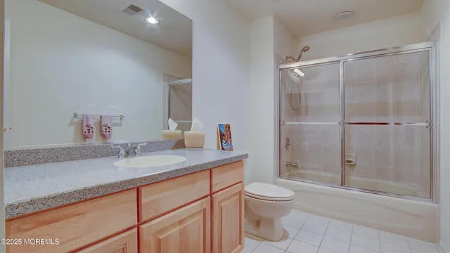 a bathroom with a granite countertop sink a toilet and shower