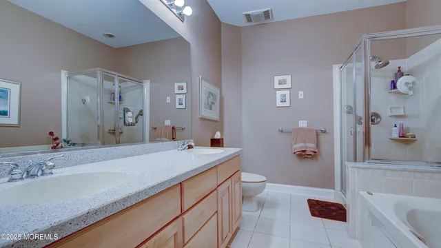 a spacious bathroom with a granite countertop sink a toilet a tub and shower