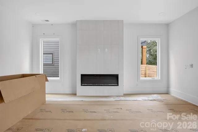 a view of an empty room with a fireplace and a window