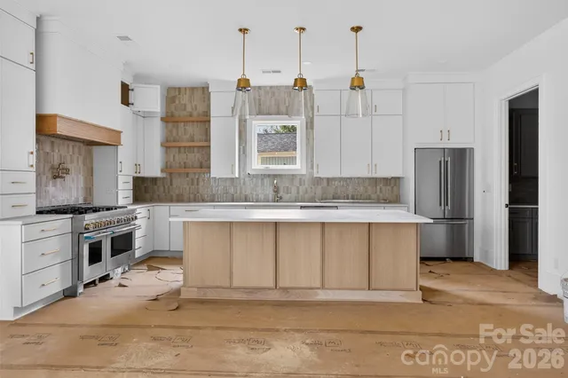 a large kitchen with granite countertop a sink stainless steel appliances and cabinets