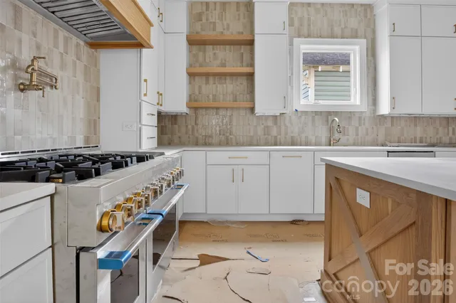 a kitchen with stainless steel appliances granite countertop a stove and a sink