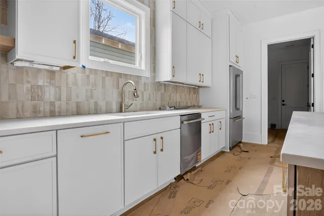 a kitchen with white cabinets and white appliances