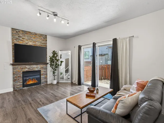 a living room with furniture a flat screen tv and a fireplace