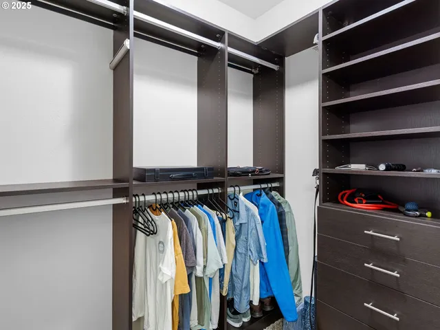 a view of walk in closet with clothes and shoes