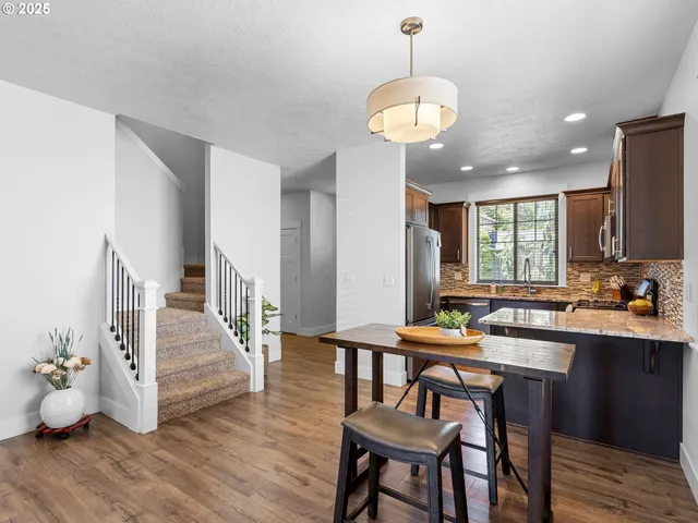 a dining room with wooden floor a chandelier a wooden table and chairs