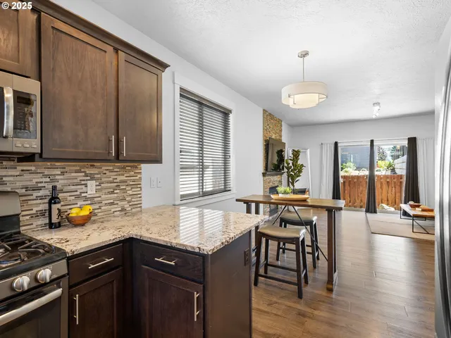 a kitchen with a sink a counter space dining table and chairs