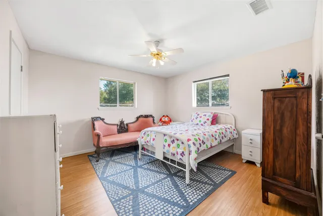 a bedroom with a bed wooden floor and dresser