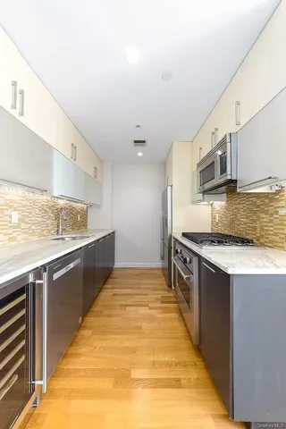 a large kitchen with stainless steel appliances granite countertop a stove a sink and a microwave