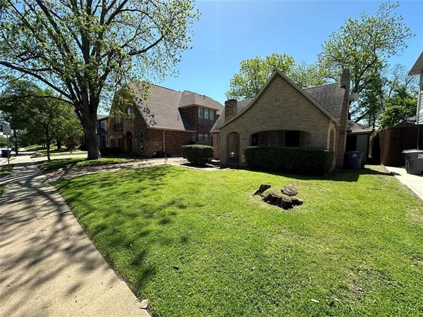 a front view of house with yard and trees in the background