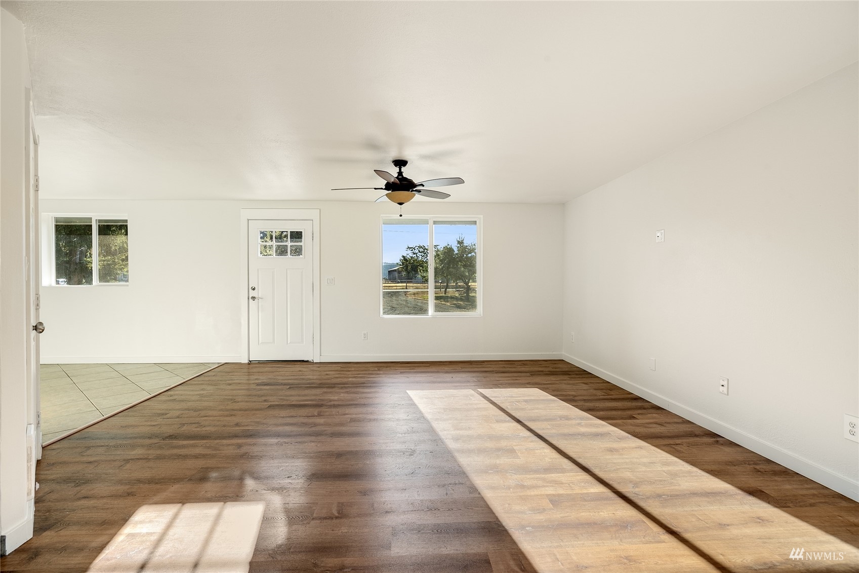 19027 Nutmeg Street Southwest Rochester, WA 98579 - Photo 6 of 22 an empty room with wooden floor windows and fan