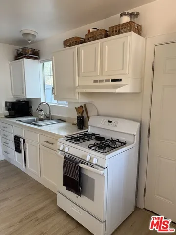 a white stove top oven sitting inside of a kitchen