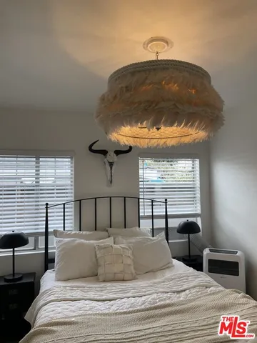 a bedroom with a bed and a chandelier