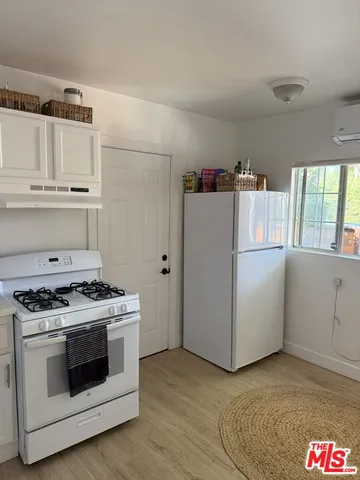 a kitchen with granite countertop white cabinets and white appliances